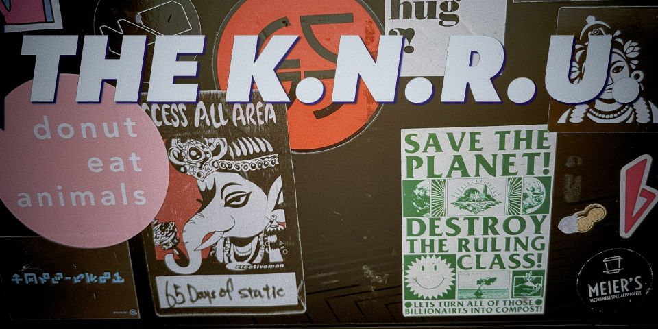 close up of a laptop covered in some EXCELLENT stickers. one says 'save the planet! destroy the ruling class!'. there's some 65daysofstatic AAA passes too