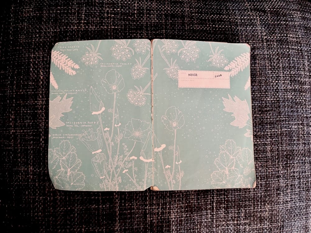 An open notebook showing a name (Nova) and a date (2006)