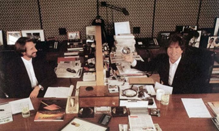 Photo of Hollywood superproducers Jerry Bruckheimer and Don Simpson with matching desks and suits.