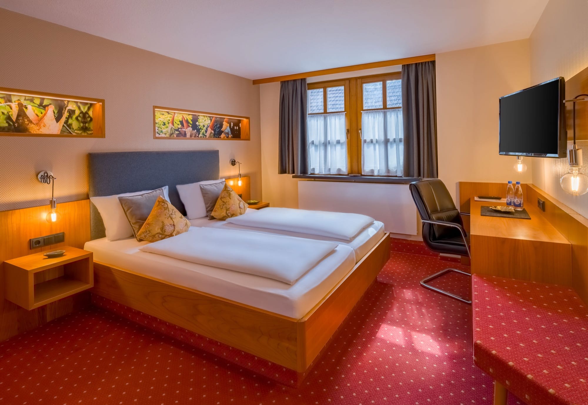 Hotelzimmer mit Doppelbett, Schreibtisch, Fernseher und Sprossenfenster, bei dem Fenster und Wandleuchten ohne Überstrahlung abgebildet sind
