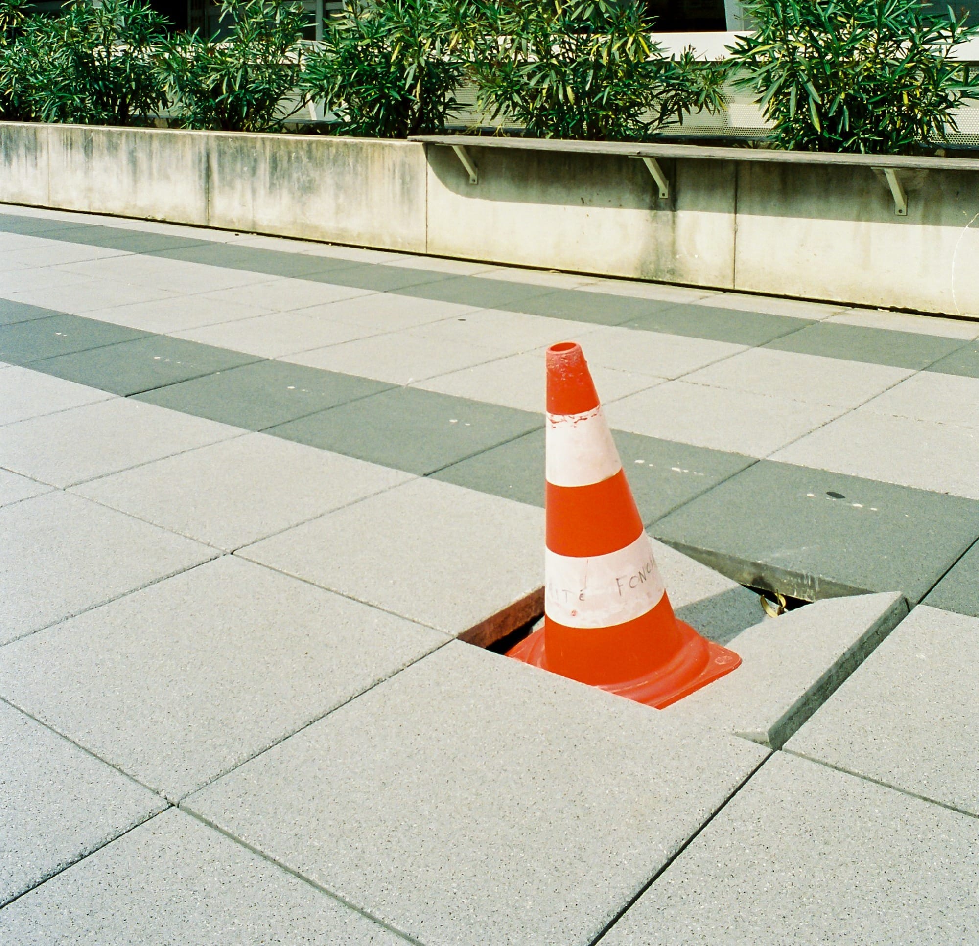 orange and white traffic cone on gray concrete floor