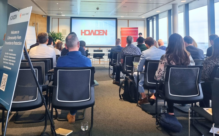 Image of people sitting in seats looking at a screen with Howden's logo on it
