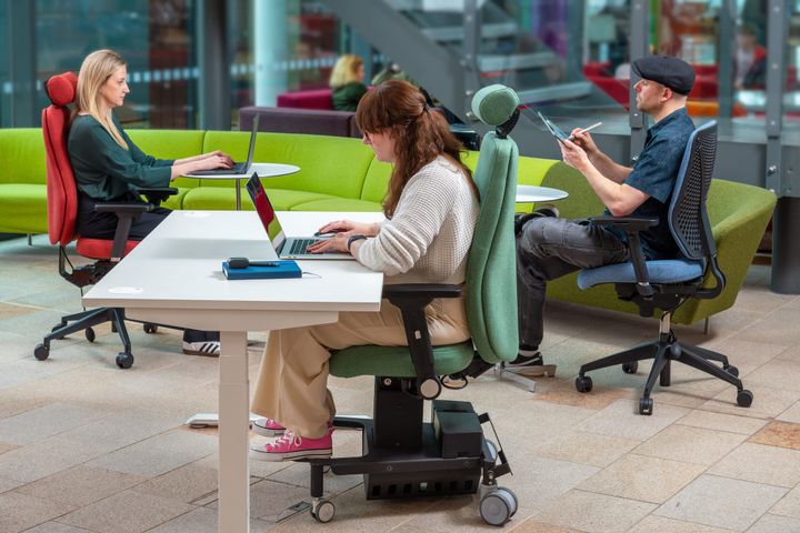 An image of three people using Ergochair's seating whilst sitting at three tables