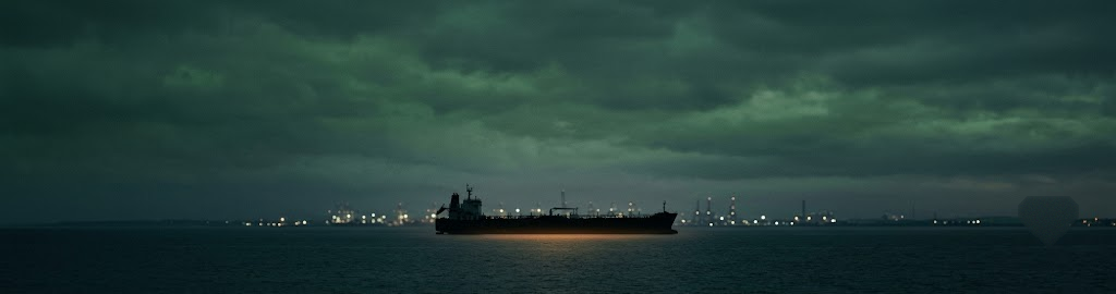 Oil tanker on dark water at dusk