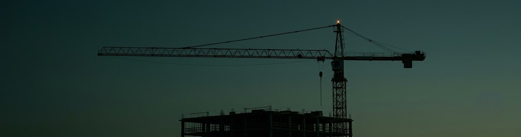 A construction crane against a dusk sky