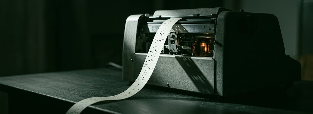 Paper tape emerging from an old teletype machine