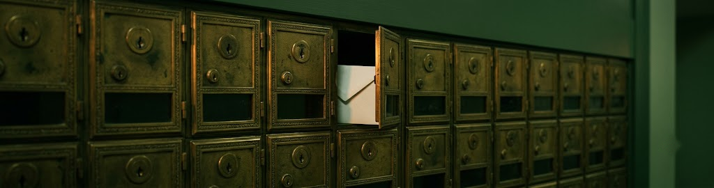 A row of brass post-office boxes, one slightly ajar