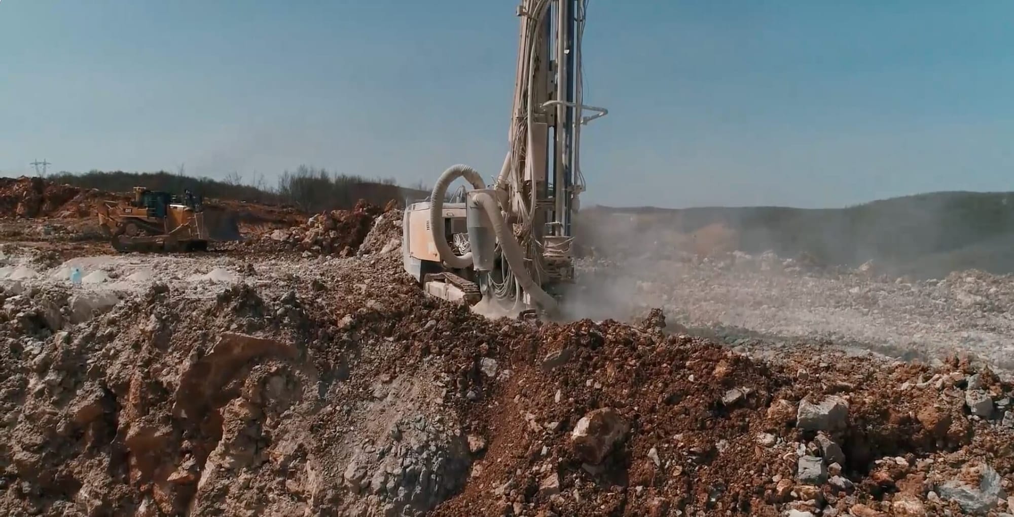 Drill rig and bulldozer at mining site