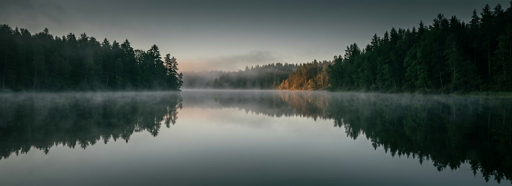 A still lake surface at dawn with no ripple