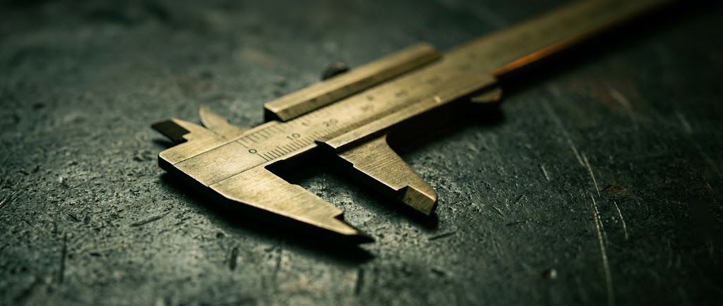Brass calipers resting on a dark surface