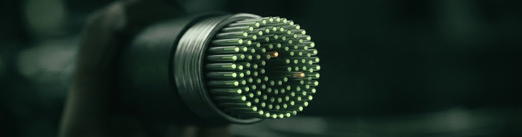 A bundle of fibre optic cables glowing at the cut ends