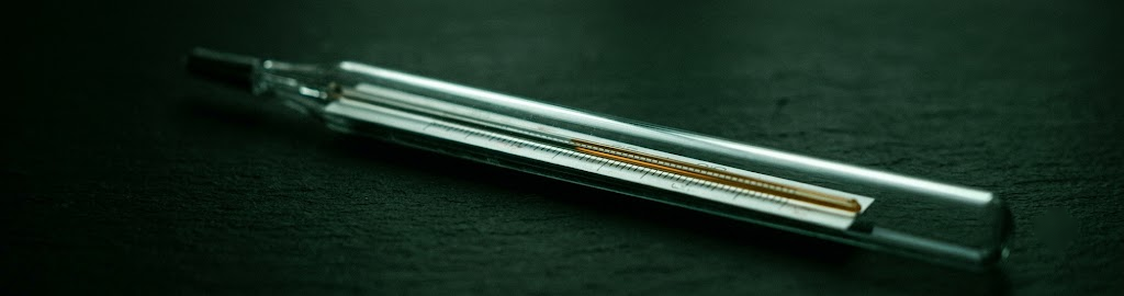 A glass thermometer against a dark background