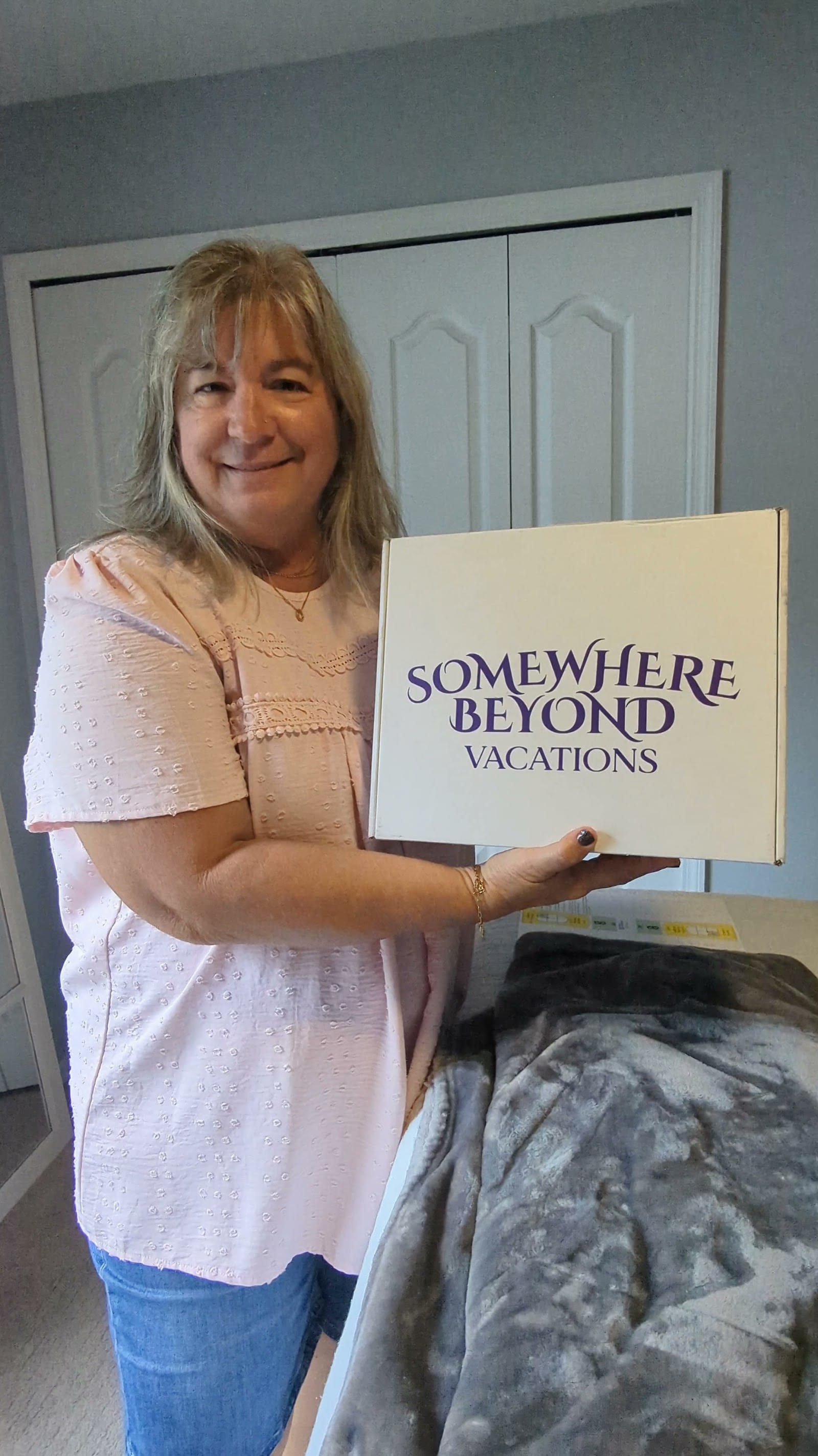 Smiling Somewhere Beyond Vacations travel advisor holding the agency's summit welcome box