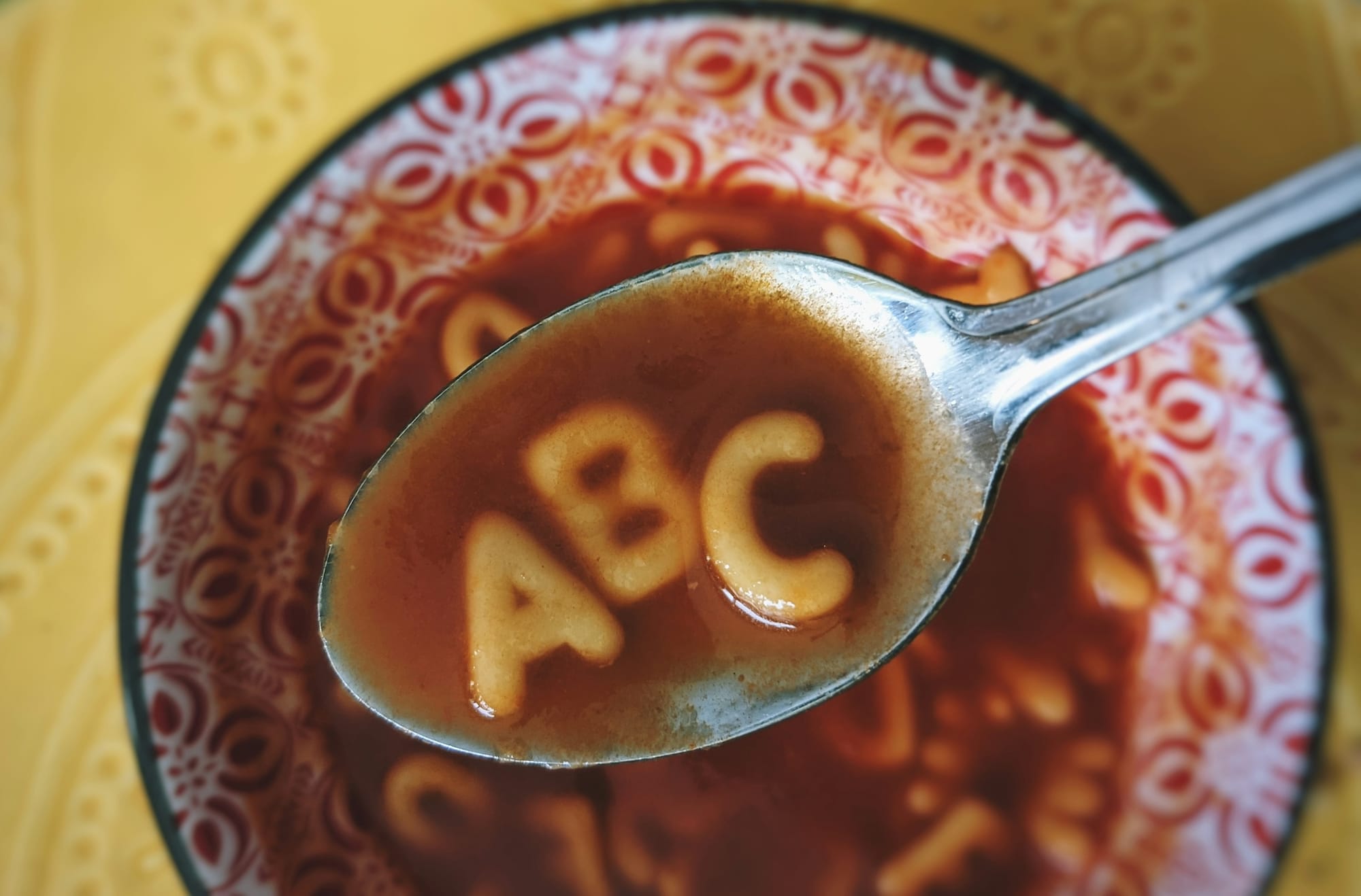 Alphabet pasta spelling A, B and C in a spoon, used to illustrate how research sites can avoid producing jumbled, search-driven content.