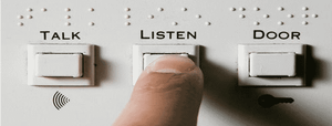 Three buttons, labelled talk, listen, door, including in braille. A finger hovers over 'listen'