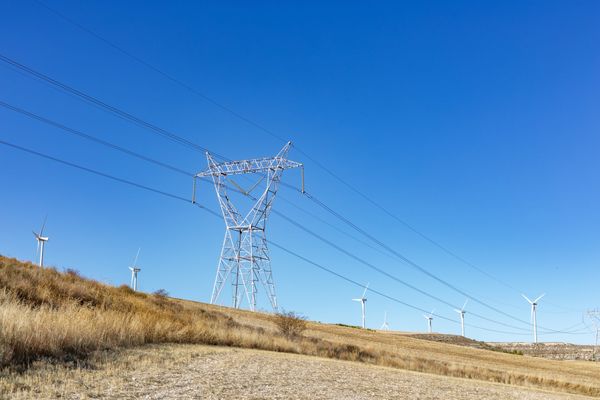 Powerlines and windmills in rural landscape