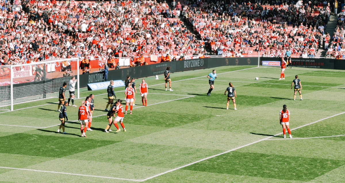 Arsenal Women in action during a match at the Emirates Stadium, accompanying an article detailing the size of banner that can be taken into the Emirates stadium