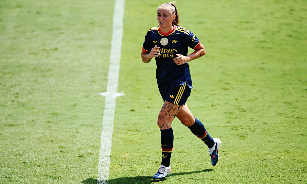 Georgia Stanway of Arsenal Women runs across the pitch during a game in Arsenal's deep blue away kit.