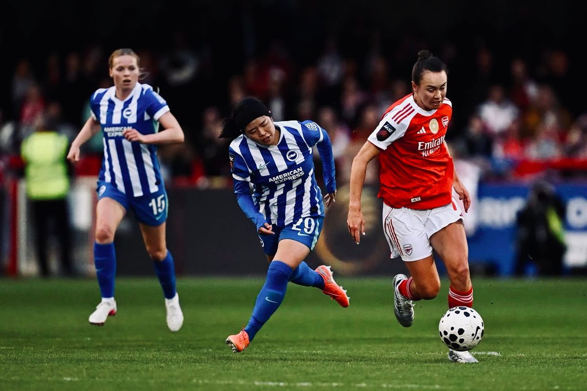Caitlin Foord of Arsenal Women carries the ball past two Brighton Women defenders