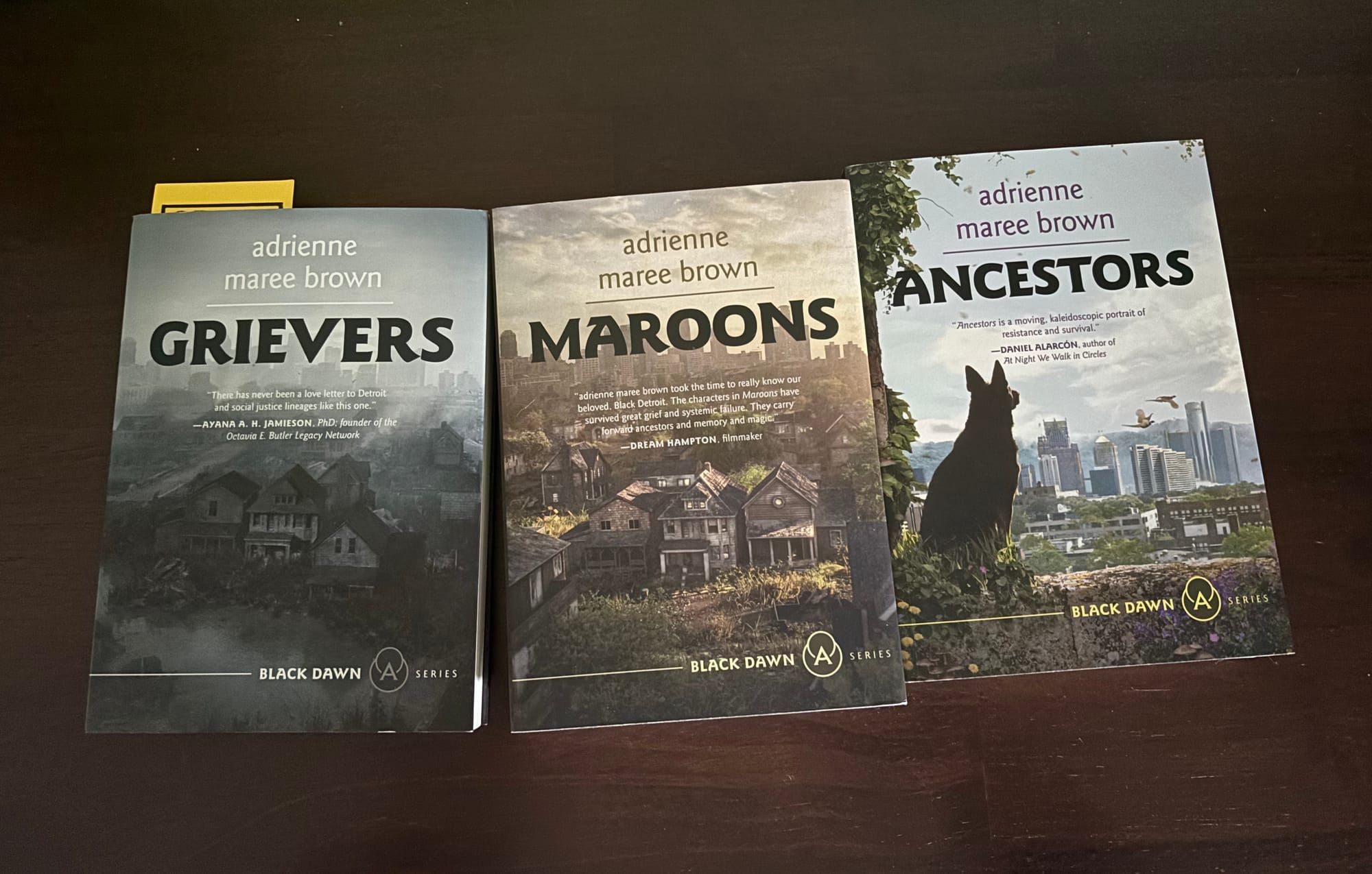 black backgroun, three books - the Grievers Trilogy by adrienne marie brown. 