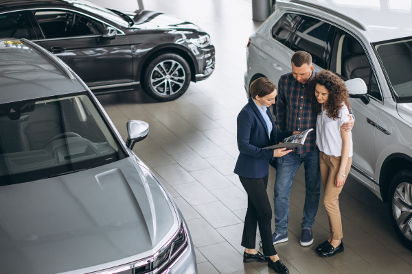 Young couple reviewing SUV insurance quotes with an agent. Modern setting focused on comparing auto insurance options