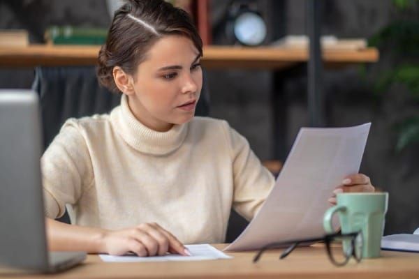 Woman reading her auto insurance declarations page at her desk