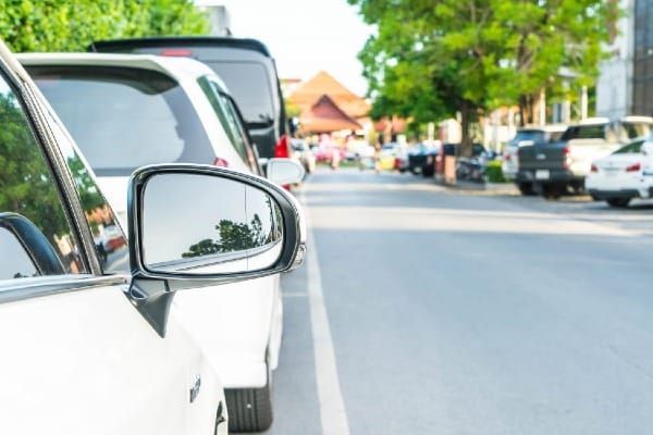Parked cars lining a quiet residential street in Florida during daylight.