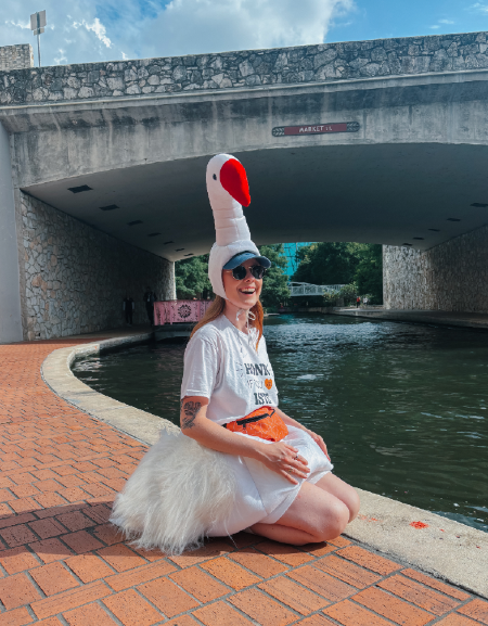 a photo of a woman under a bridge with a bird hat on