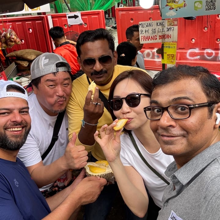 a photo of people looking at the camera eating jackfruit