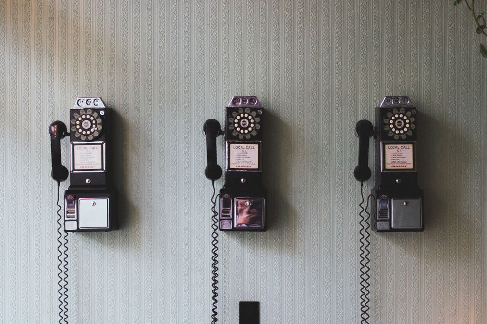 Image of three telephones on a wall