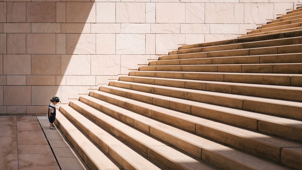 Small child looking up at a long set of stairs