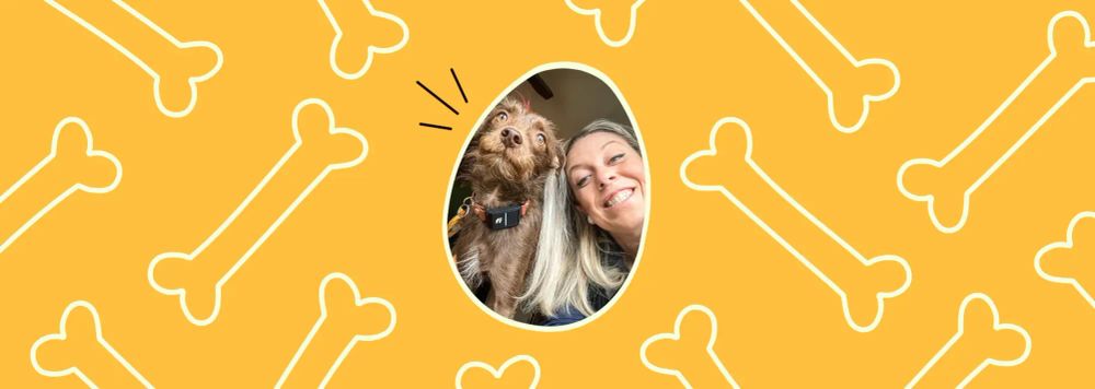 A smiling woman poses cheek-to-cheek with a small brown scruffy dog in an oval-framed photo, set against a bright yellow background patterned with illustrated dog bones.