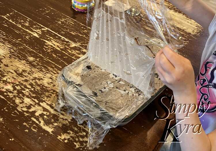 Peeling back the plastic wrap.