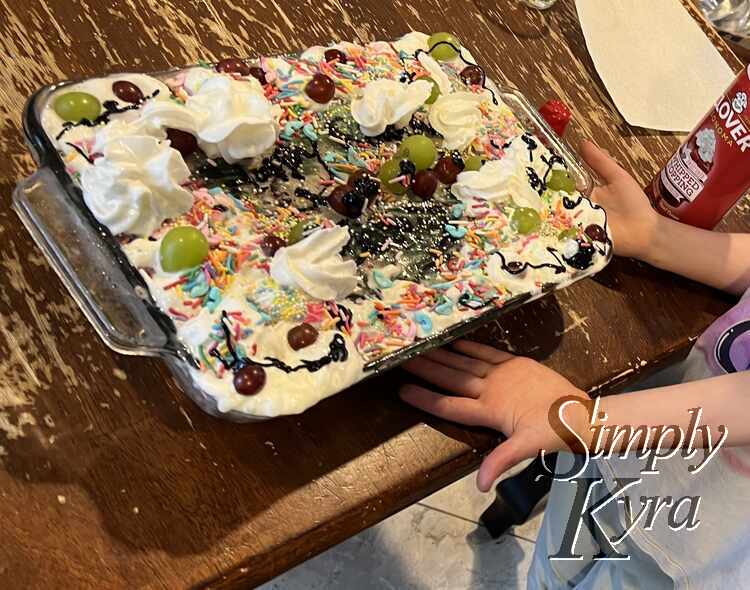 Zoey presenting her rainbow grape cake. 