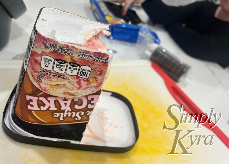 Image shows the ice cream container cut in half balanced on the lid while Ada is using the Oreos behind.