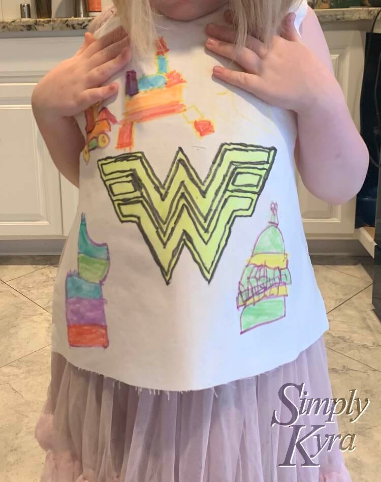Ada holding up a designed fabric panel to her chest. 
