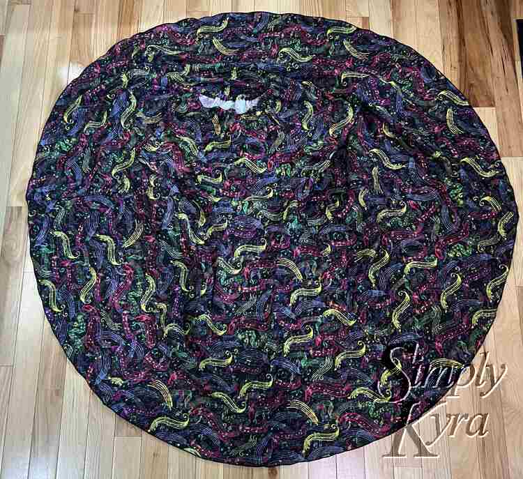 Image shows a flat lay of the spread out circle skirt. The bodice is mostly hidden in the fabric pattern. 