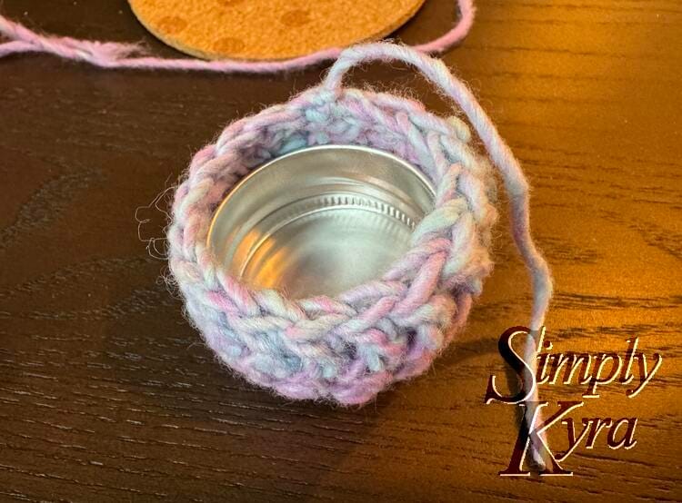 The lid is now flipped upside down so you can now see the excess yarn out the sides.