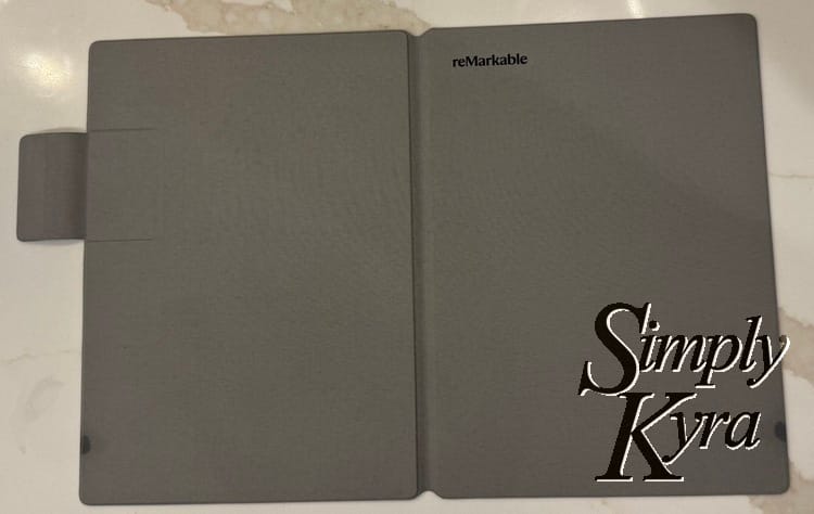 Image shows the reMarkable cover opened flat with the back and front facing up. 