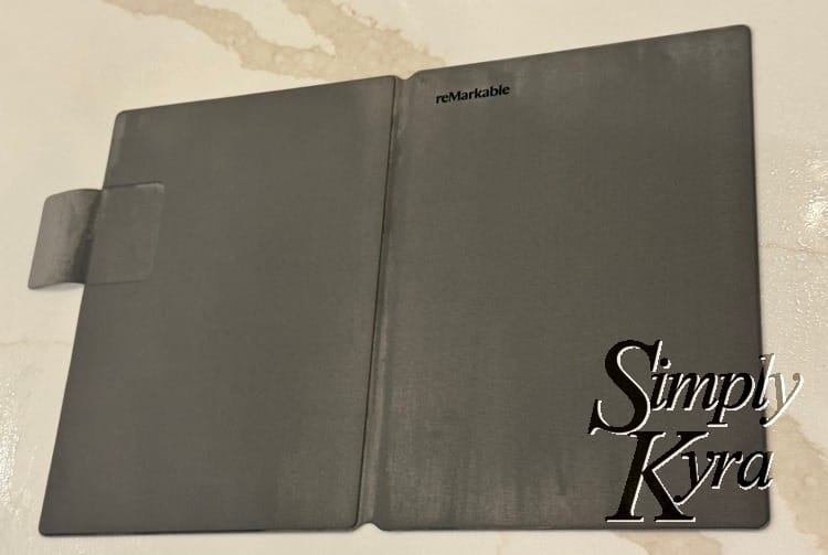 Image shows the reMarkable cover opened flat with the back and front facing up with vertical streaks all over it. 