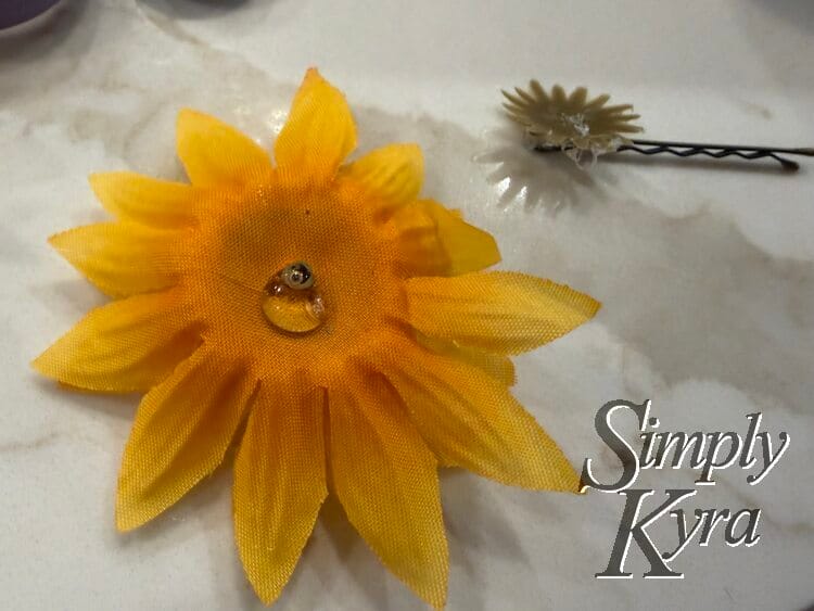 Closeup of the upside down flower with glue and the bobby pin in the back with the green base.