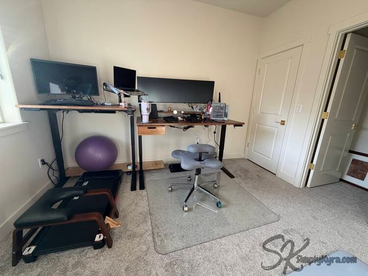 Two desks at different heights side by side with laptop between them.