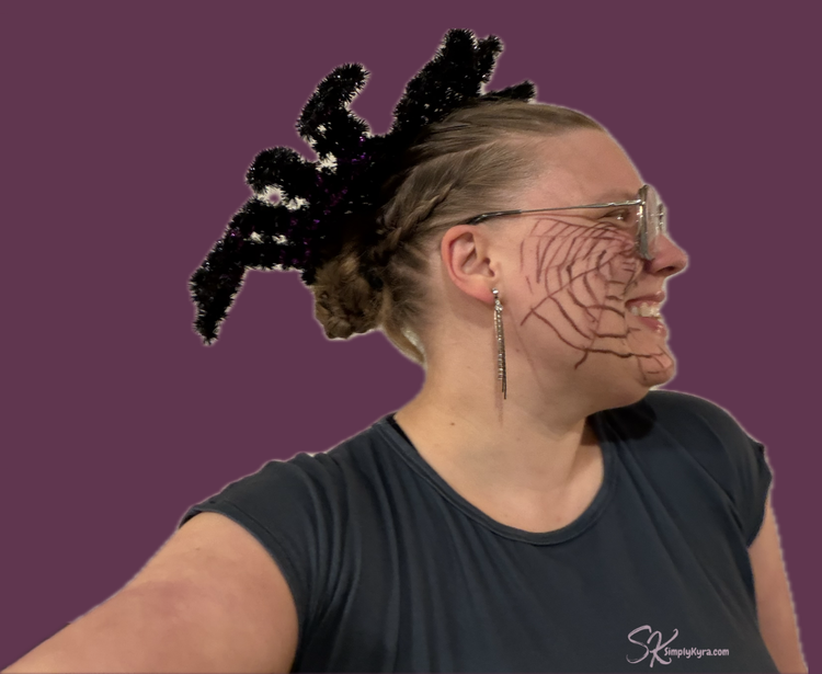 Sticker photo of me wearing the spider with a web on half my face.