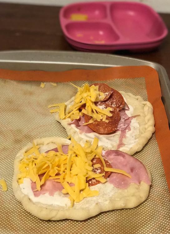 Closeup of the final two pizzas on the silpat lined cookie sheets.