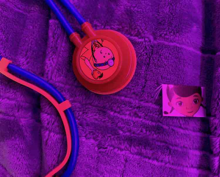 Stethoscope with Caillou's face on it to the left and a small piece of ribbon to the right.