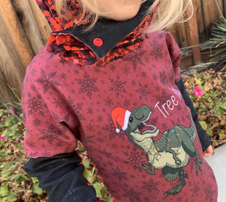 Closeup of Zoey's half fastened hood. The bottom snap is snapped but the top isn't letting her chin stick out over the top of the flap so her mouth isn't covered.