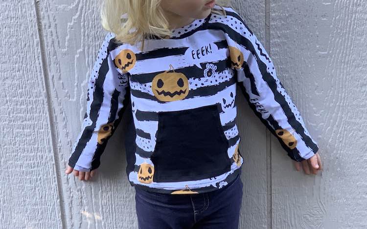 Close view of the front of the pumpkin shirt on Zoey.