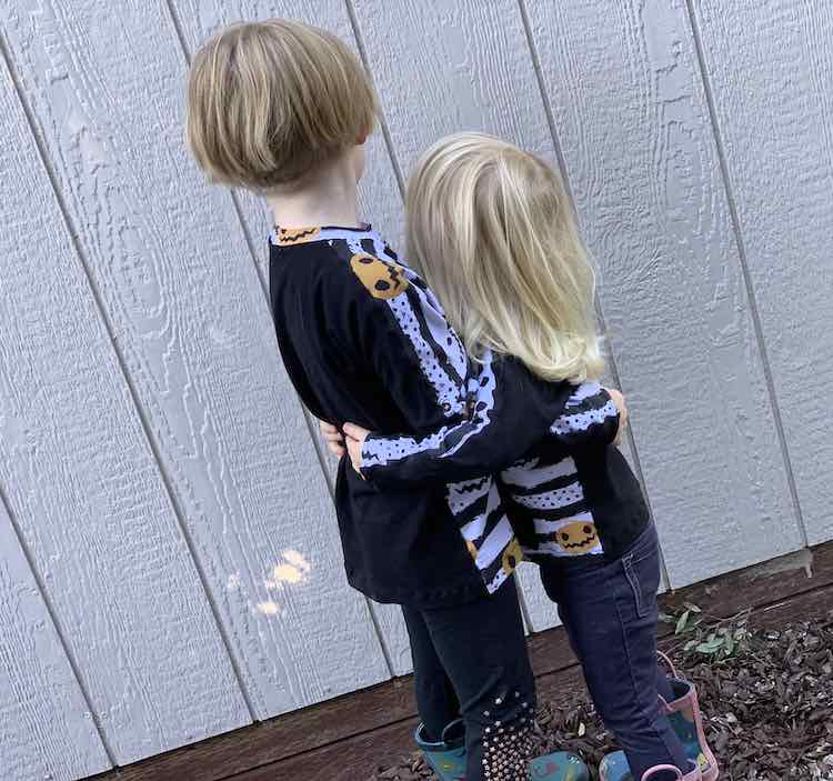 Side view of the shirts while the girls hug each other.