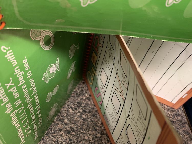 Two water wow books on it's side and spread open. The second is balanced on top of the first.