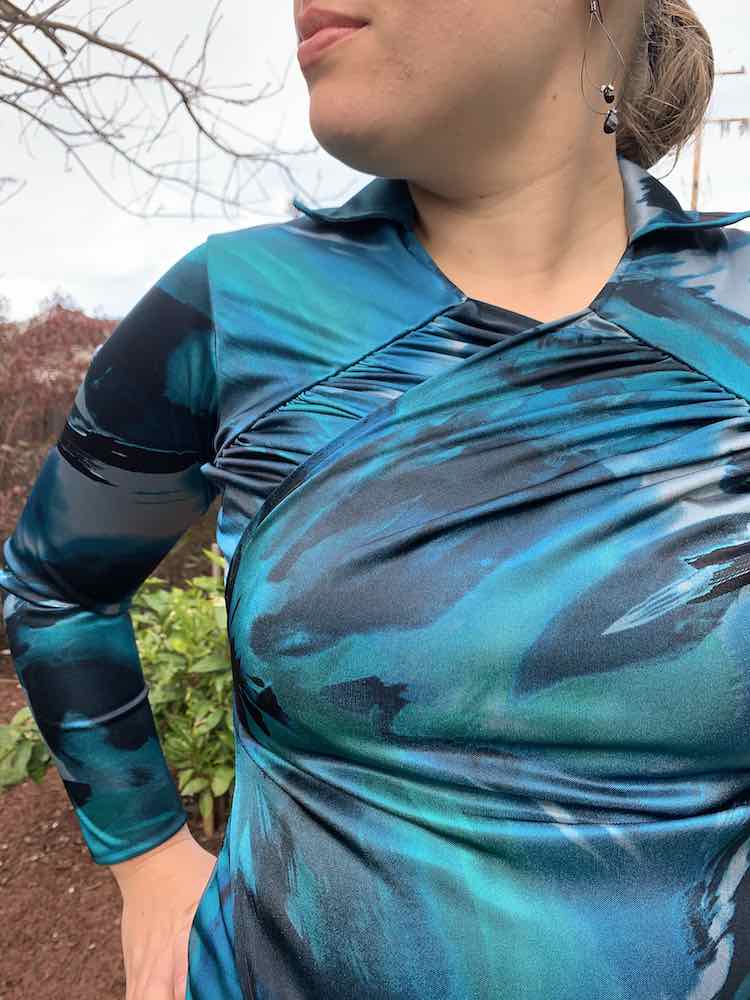 Closeup fornt view of the bodice, simple collar, and one sleeve (in the background).